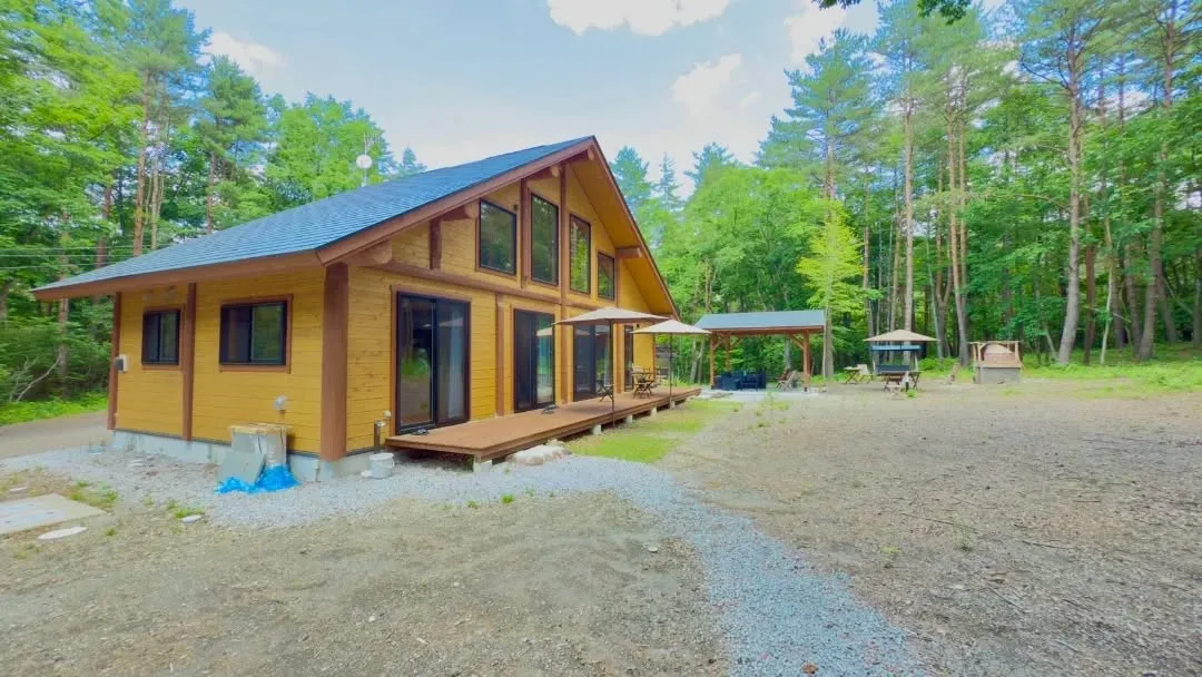 夜の森に静かに佇む建物は、周囲の暗闇の中でやわらかな光を放ち...